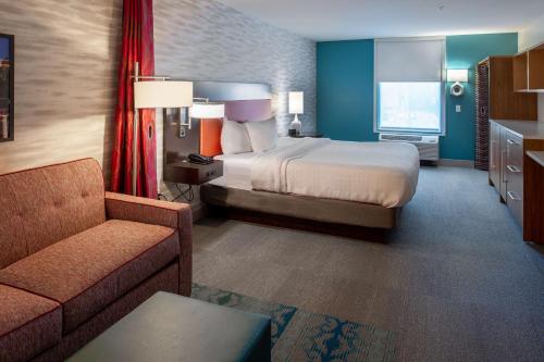 um quarto de hotel com uma cama e um sofá em Home2 Suites St. Louis / Forest Park em Richmond Heights