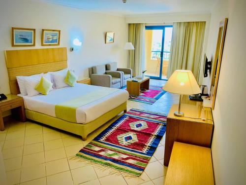 ハルガダにあるEagles Downtown Resortのベッドとリビングルームが備わるホテルルームです。