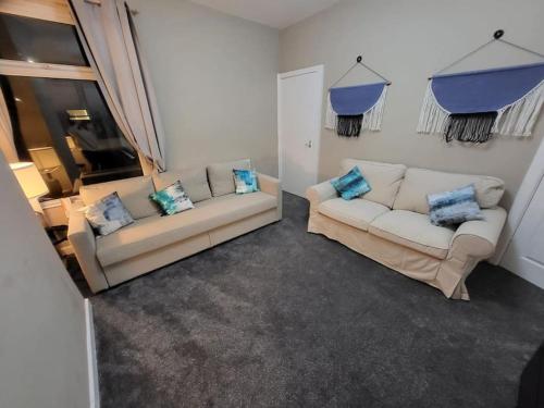 a living room with two white couches and blue pillows at 4 Bedrooms, 8 min to Manchester City! in Manchester