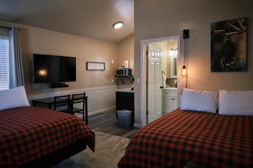 a hotel room with two beds and a flat screen tv at Chinook Wind Cabins in Talkeetna