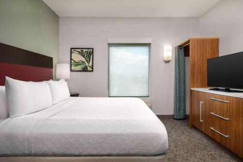a bedroom with a bed and a flat screen tv at Home2 Suites by Hilton Tallahassee State Capitol in Tallahassee