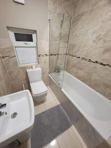 a bathroom with a toilet and a sink and a shower at 4 Bedrooms, 8 min to Manchester City! in Manchester