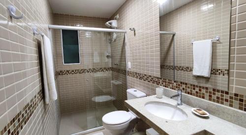 a bathroom with a toilet and a sink and a shower at Areias do Mar ! 2 Quartos Vista Mar e Varanda A204 in Barra de São Miguel