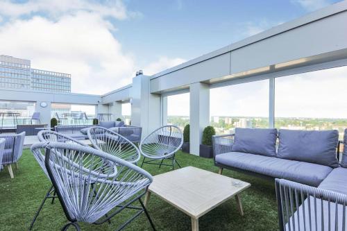 a patio with chairs and a couch on a roof at Lovely apartment in the centre of Croydon in Croydon