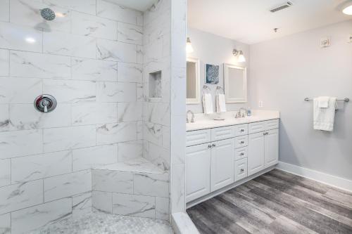 a white bathroom with two sinks and a shower at Waterscape C206 Ground Floor in Fort Walton Beach