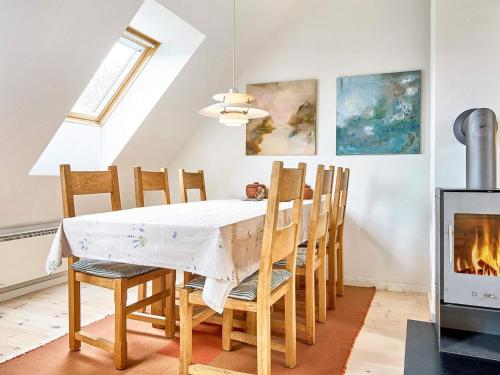 スヴァネケにある5 person holiday home in Svanekeのダイニングルーム(テーブル、椅子、暖炉付)