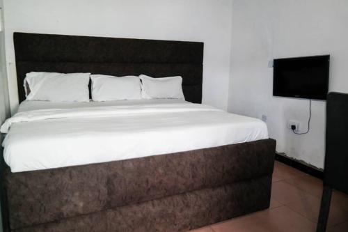 um quarto com uma cama e uma televisão de ecrã plano em D'Island hotel and club em Lekki
