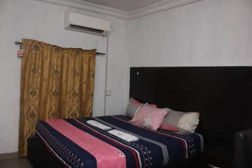 a bedroom with a bed with a black headboard and pillows at D'Island hotel and club in Lekki