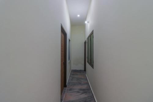 a hallway of a house with white walls at SPOT ON The Greenwoods Retreat in Jhājra