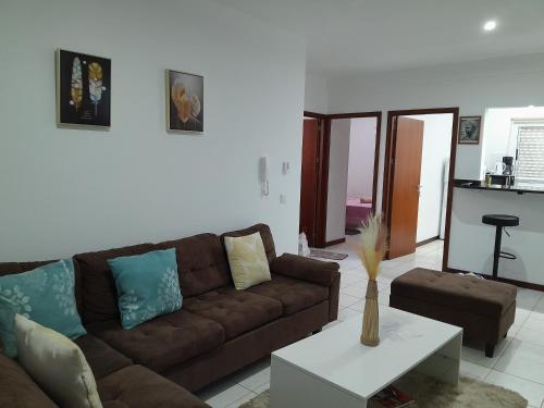 ein Wohnzimmer mit einem Sofa und einem Tisch in der Unterkunft AP Hélder Bentub in Ponta do Sol