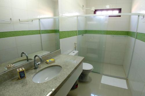 een badkamer met een wastafel, een douche en een toilet bij Casa Janga Mar in Barra de São Miguel