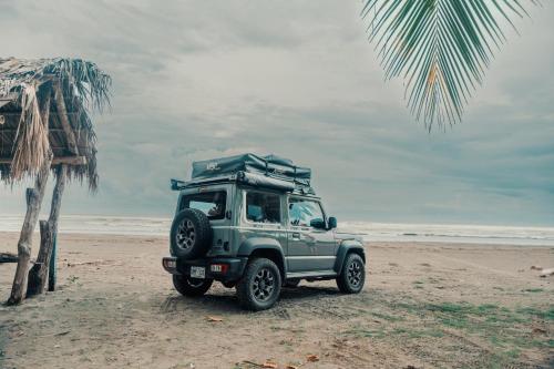 una jeep verde parcheggiata sulla spiaggia di 4BOX4 - 4x4 Car Rentals Only - SJO Airport a Río Segundo