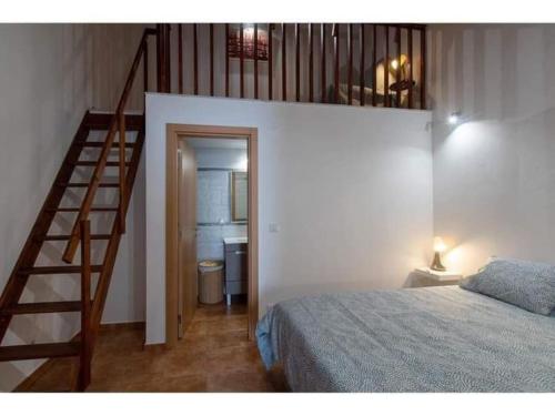 1 dormitorio con escalera, 1 cama y escalera en Sentinela Place, en Azinhal