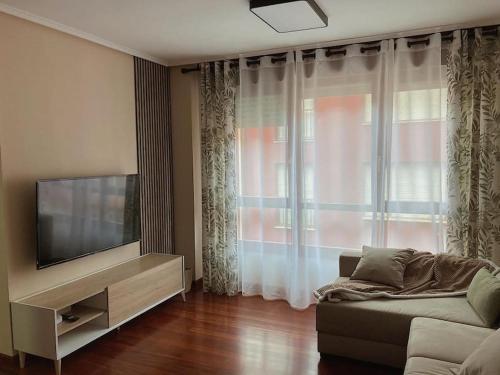 Apartamento Hogar del Nómada في Gibaja: غرفة معيشة مع أريكة وتلفزيون بشاشة مسطحة