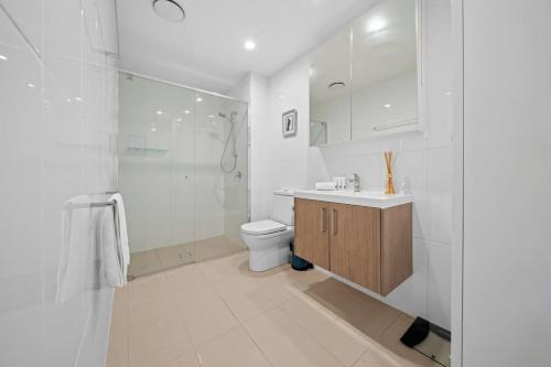 y baño blanco con aseo y ducha. en Impeccable 1-Bed with Alfresco Dining in Barton, en Kingston 