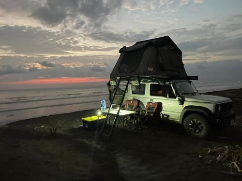 a white jeep parked on the beach with a surfboard at 4BOX4 - 4x4 Car Rentals Only - SJO Airport in Santiago Este