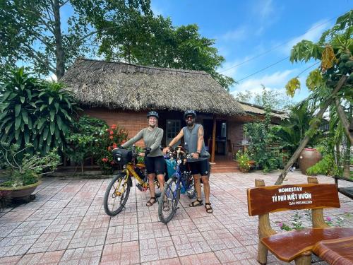two people on bikes in front of a building at Ty Phu Miet Vuon Homestay - Entire Bungalow in Tây Ninh