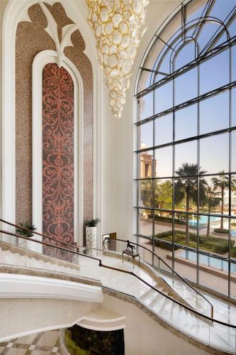 a lobby with a large window and a chandelier at Marsa Malaz Kempinski, The Pearl in Doha