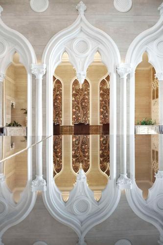 a reflection of a building in a pool of water at Marsa Malaz Kempinski, The Pearl in Doha