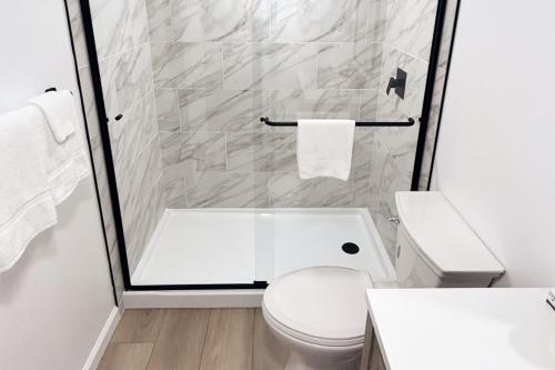 a white bathroom with a shower and a toilet at The Salty Crab in Annapolis