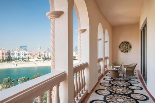 a balcony with a view of a pool at Marsa Malaz Kempinski, The Pearl in Doha