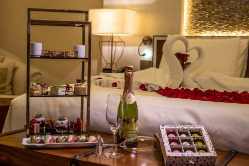 a bottle of champagne on a table next to a bed at Marsa Malaz Kempinski, The Pearl in Doha