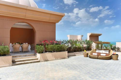 a patio with chairs and flowers on a building at Marsa Malaz Kempinski, The Pearl in Doha