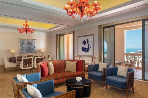 a living room with a couch and chairs and a chandelier at Marsa Malaz Kempinski, The Pearl in Doha