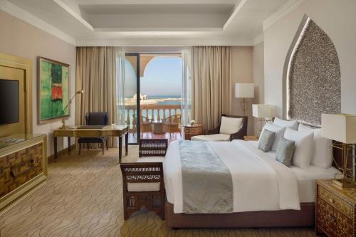 a hotel room with a large bed and a large window at Marsa Malaz Kempinski, The Pearl in Doha