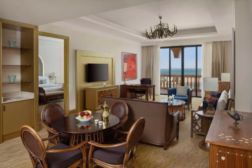 a hotel room with a living room with a view of the ocean at Marsa Malaz Kempinski, The Pearl in Doha