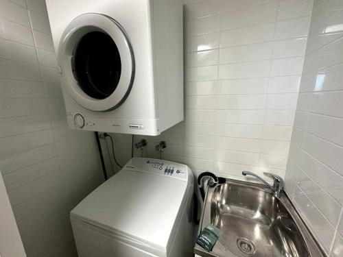 a washing machine on top of a toilet in a bathroom at Massive Wings Apartment - 1 Block From Beach in Gold Coast