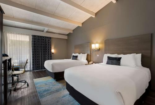um quarto de hotel com duas camas e uma televisão em The Hub Middletown Red Bank- Best Western Signature Collection em Middletown