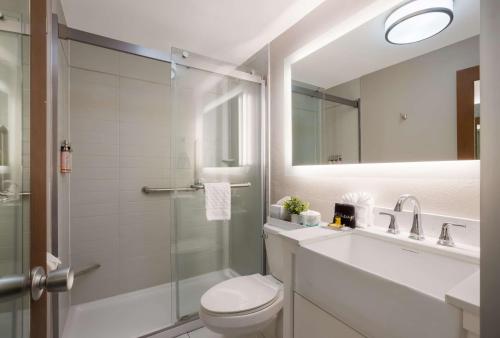 a bathroom with a shower and a toilet and a sink at The Hub Middletown Red Bank- Best Western Signature Collection in Middletown