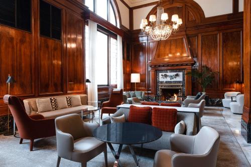 a living room filled with furniture and a fireplace at The Benson Portland, Curio Collection by Hilton in Portland