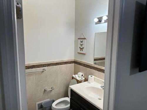 y baño con lavabo, aseo y espejo. en Deluxe 2 bedroom EWR airport home, en Elizabeth