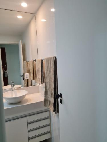 a bathroom with a sink and a mirror at Flat Praia da Costa in Vila Velha