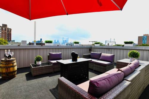 een dakterras met banken en een rode parasol bij Yanne's Place - Dual-Lounge in Philadelphia