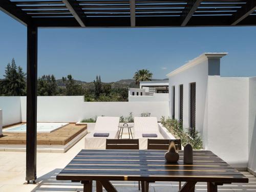 a patio with a bench and a table at Lindian Village All Inclusive Resort Rhodes,Curio Collection in Kiotari