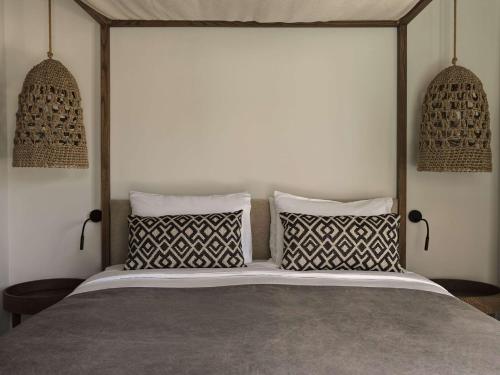a bedroom with a large bed with two pillows at Lindian Village All Inclusive Resort Rhodes,Curio Collection in Kiotari