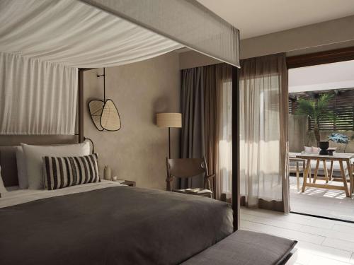 a bedroom with a bed and a patio with a table at Lindian Village All Inclusive Resort Rhodes,Curio Collection in Kiotari