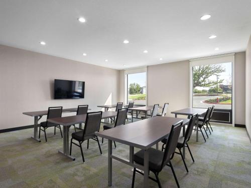 a conference room with tables and chairs and a flat screen tv at Home2 Suites By Hilton Round Rock Medical Center in Round Rock