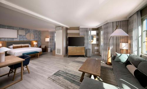 a hotel room with a bed and a couch at Inn at the Pier Pismo Beach, Curio Collection by Hilton in Pismo Beach