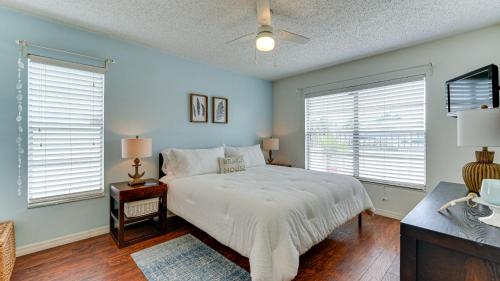 a bedroom with a white bed and two windows at Cozy Pet-Friendly Private Pool Near Beaches in Bradenton