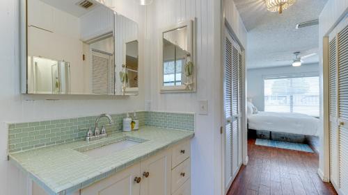 a white kitchen with a sink and a bedroom at Cozy Pet-Friendly Private Pool Near Beaches in Bradenton