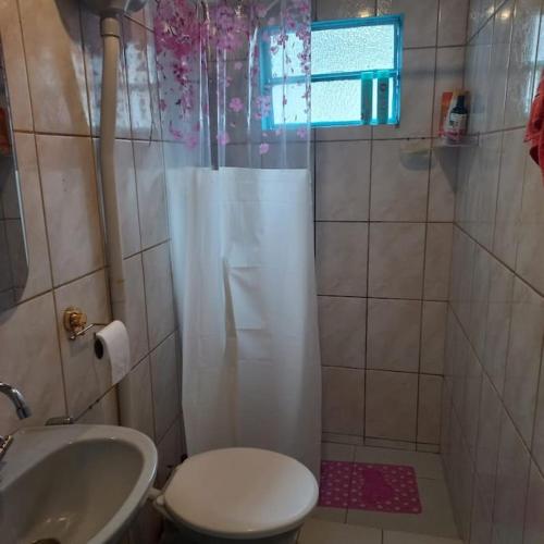 uma casa de banho com um chuveiro, um WC e um lavatório. em Casa da Bru pertinho da praia e da lagoa em Rio das Ostras