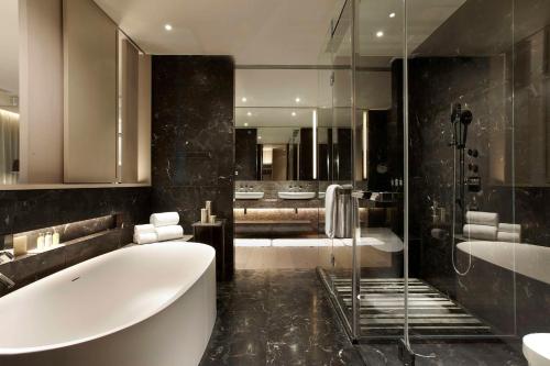 a bathroom with a large tub and a shower at Humble House Taipei, Curio Collection by Hilton in Taipei