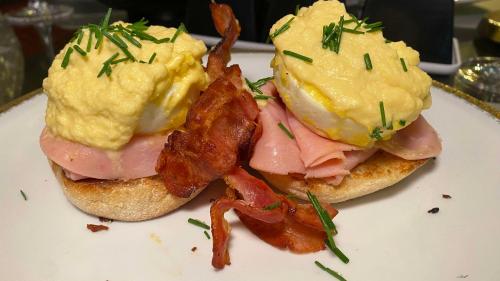 two breakfast sandwiches with bacon and eggs on a plate at Hotel Black Boutique in Mexico City