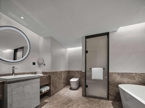 a bathroom with a sink and a toilet and a mirror at Hilton Garden Inn Hangzhou West Lake in Hangzhou