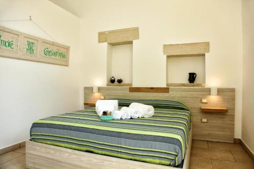 a bedroom with a bed with two towels on it at Manipinta B&B in Corigliano dʼOtranto
