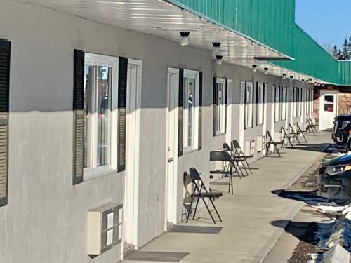 a row of chairs sitting on the side of a building at Castle Motel in Edson